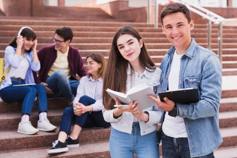 students-standing-with-open-books-and-looking-at-camera